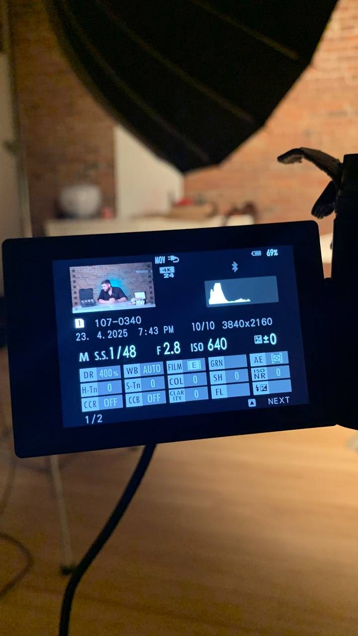 Camera screen showing recording settings, with a softbox light above